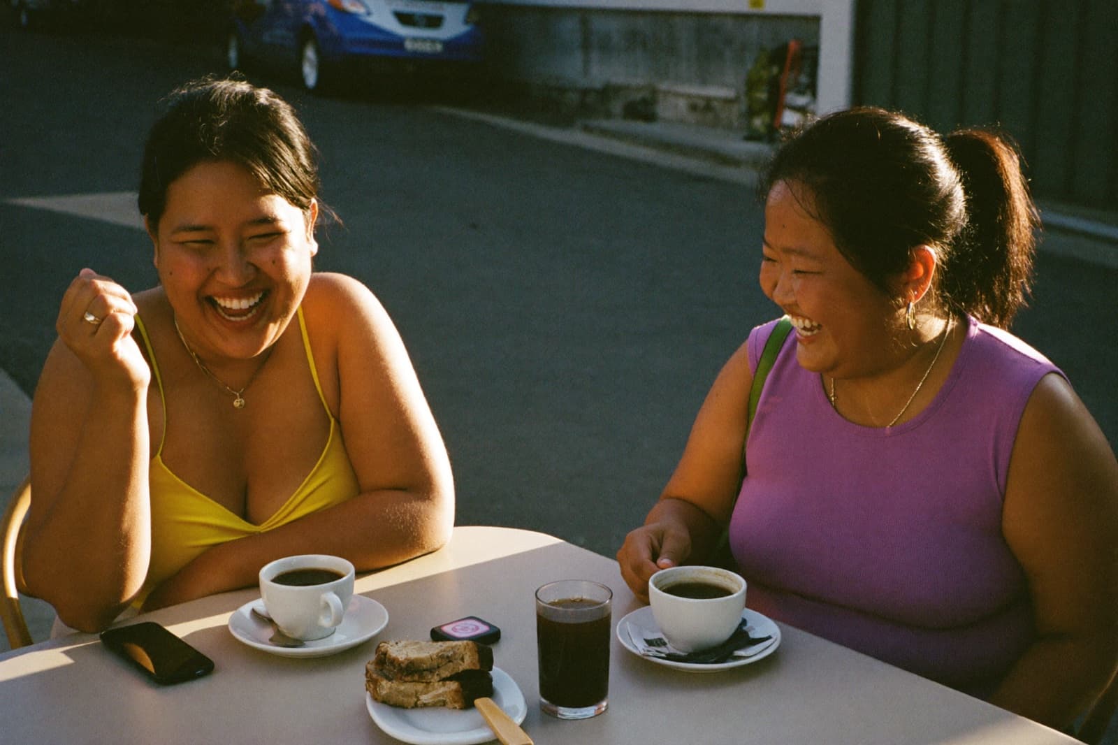 Two friends laughing over coffee